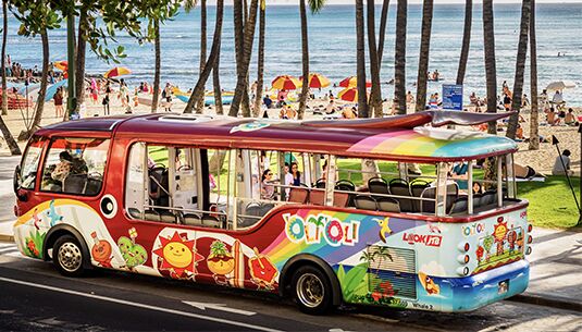A tour bus drives down Kalakaua Ave. in Waikiki on Oahu.